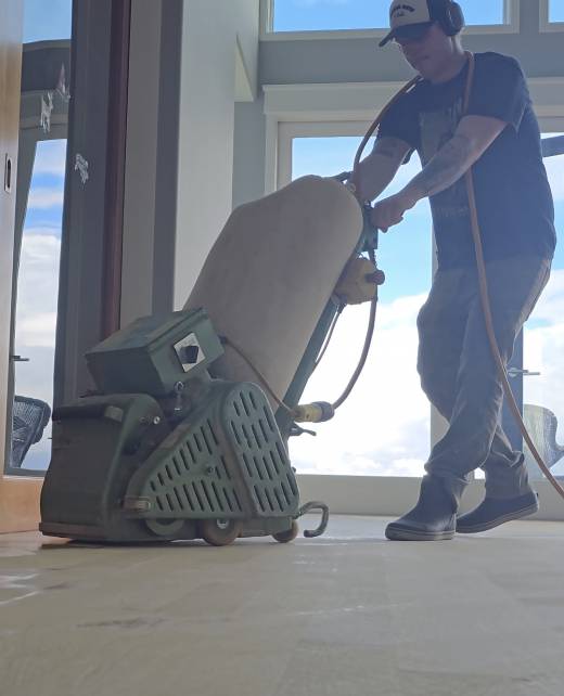 Jeff Bueler Refinishing Floor Man using tool to sand hardwood floor